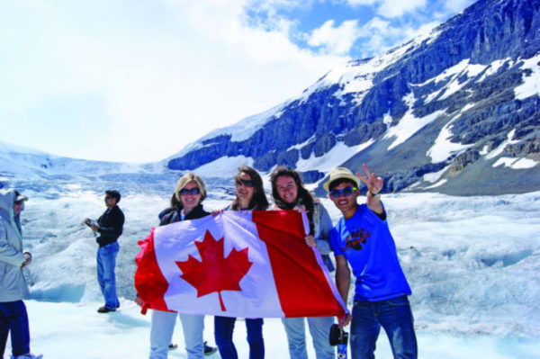 Sprachreise Vancouver Sprachschüler auf Gletscher im Schnee mit kanadischer Flagge