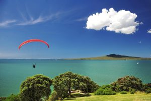 Roter Fallschirmspringer über wunderschöner Bucht in Neuseeland