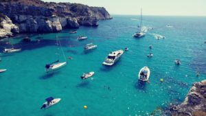 Sprachreise 50 Plus Menorca mit kristallblauem Wasser und kleinen Booten